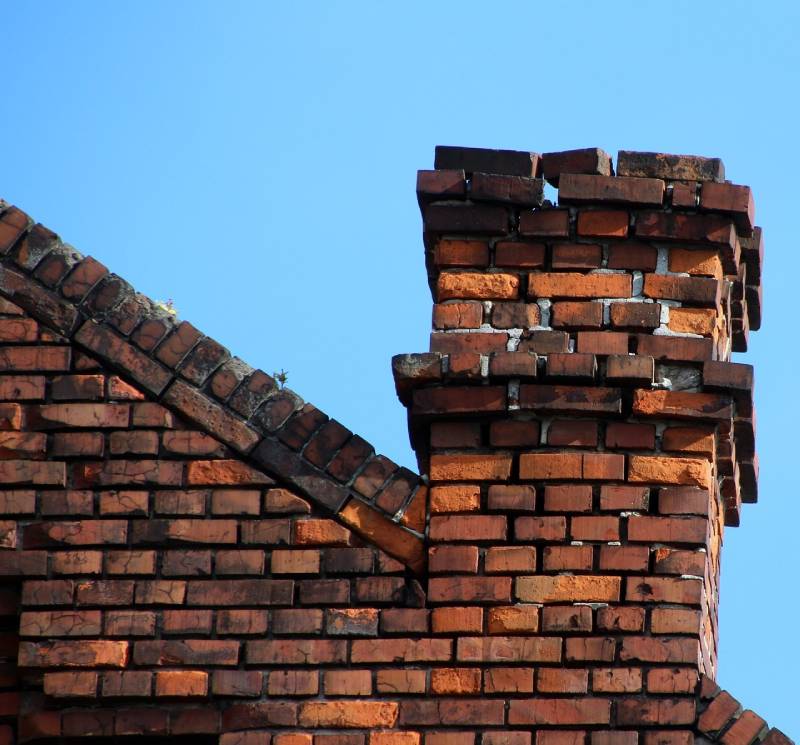 Damaged chimney on an Dania Beach home showing cracks and missing mortar